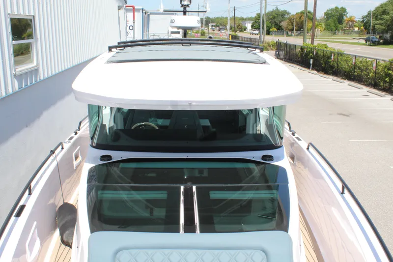 Slide: The Image of 2022 Axopar 37 XC Cross Cabin Brabus boat, top view, docked near a building. - 36