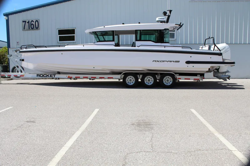 Slide: The Image of 2022 Axopar 37 XC Cross Cabin Brabus boat on a Rocket trailer in a parking lot. - 15