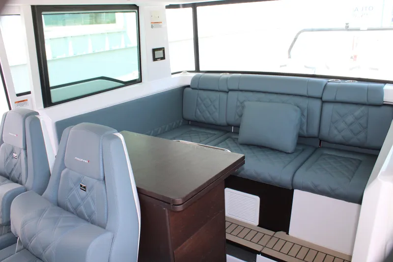 Slide: The Image of Interior of 2022 Axopar 37 XC Cross Cabin Brabus with blue seating and wooden table. - 47