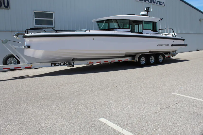 Slide: The Image of 2022 Axopar 37 XC Cross Cabin Brabus on a trailer outside a warehouse. - 11
