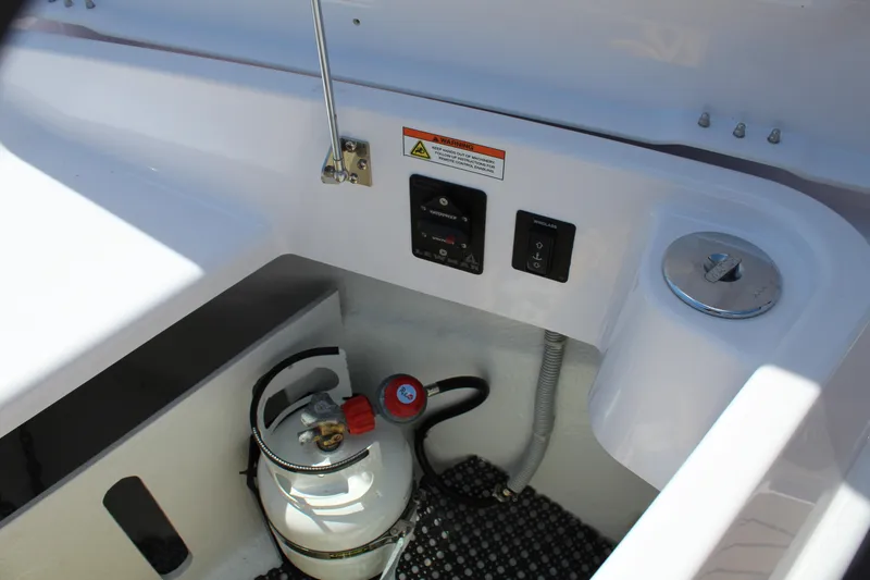 Slide: The Image of Axopar 37 XC Cross Cabin Brabus 2022 boat storage compartment with propane tank and control panel. - 45
