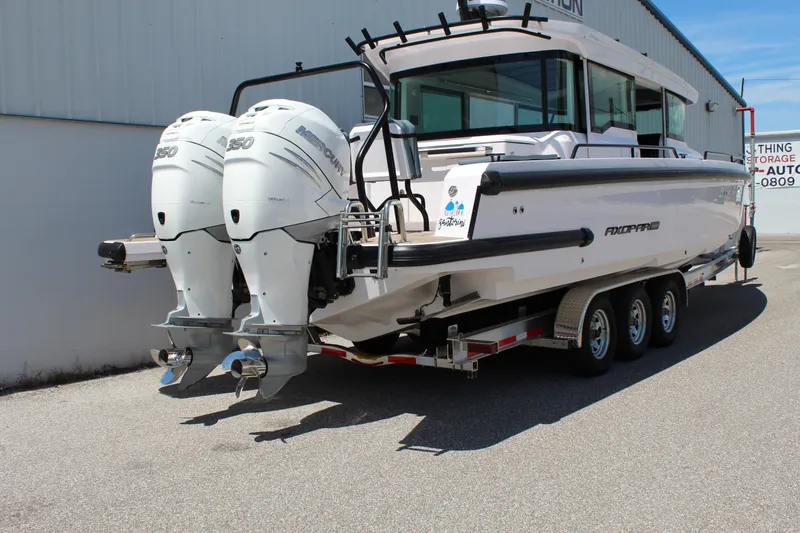 Slide: The Image of 2022 Axopar 37 XC Cross Cabin Brabus with twin outboard engines on a trailer. - 7