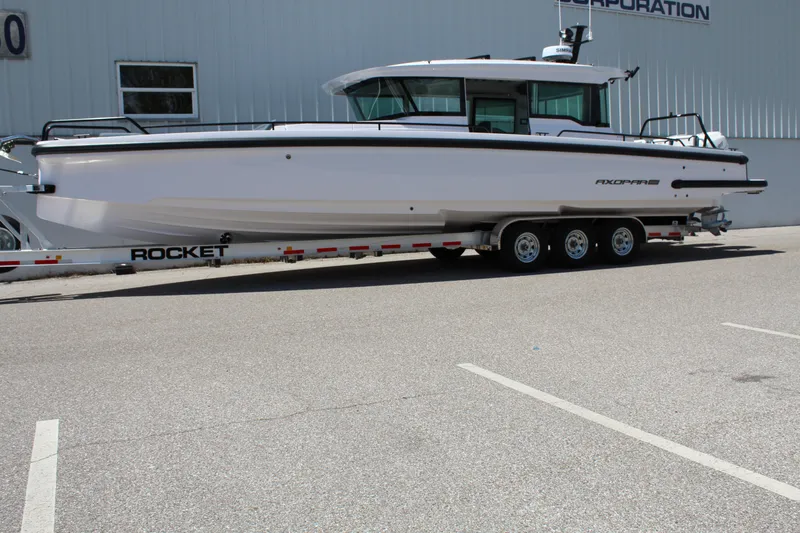 Slide: The Image of 2022 Axopar 37 XC Cross Cabin Brabus on a trailer in a parking lot. - 14