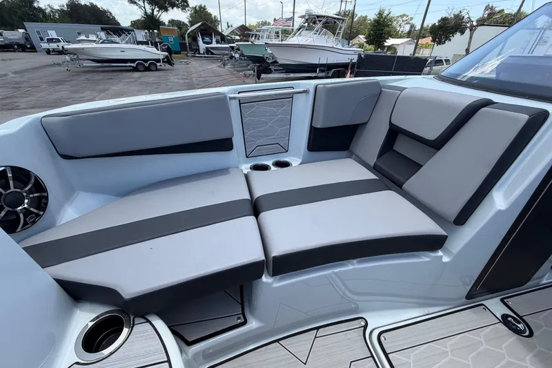 Slide: The Image of L'image montre la zone de sièges d'un Yamaha Boats 222XD 2024 avec des sièges gris et des porte-gobelets. - 46