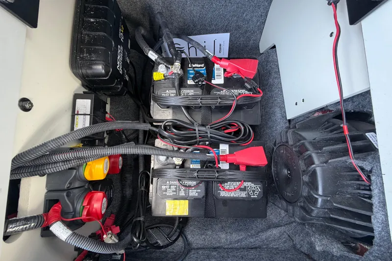 Slide: The Image of 2024 Yamaha Boats 222XD battery compartment with wiring and components. - 65