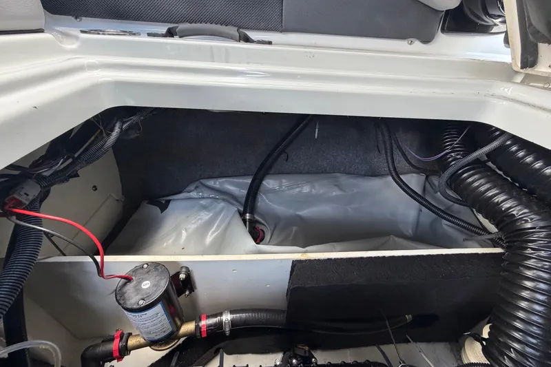 Slide: The Image of Interior view of 2024 Yamaha Boats 222XD engine compartment with wiring and components. - 70