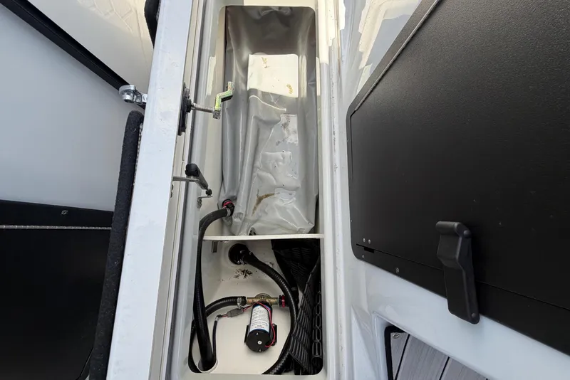 Slide: The Image of An open storage compartment on a Yamaha 222XD boat, showing cables and a pump. - 34