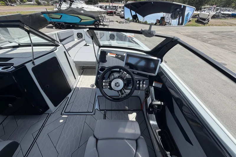 Slide: The Image of La imagen muestra la cabina de un barco Yamaha 222XD 2024 con un timón moderno y asientos grises. - 21