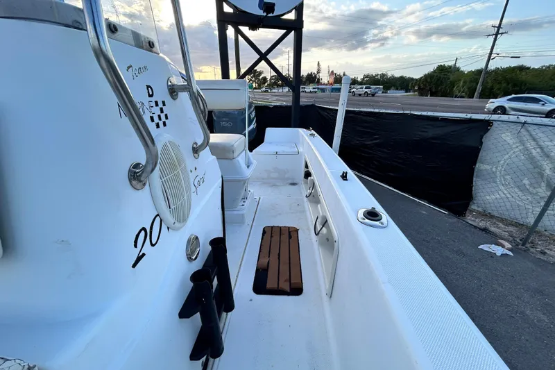 Slide: The Image of 1999 Hydra-Sports 2000 CC boat interior with seating and rod holders, parked near a road. - 34