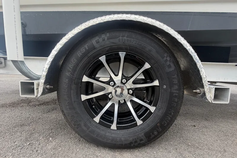 Slide: The Image of Trailer wheel of a 1999 Hydra-Sports 2000 CC boat on pavement. - 51