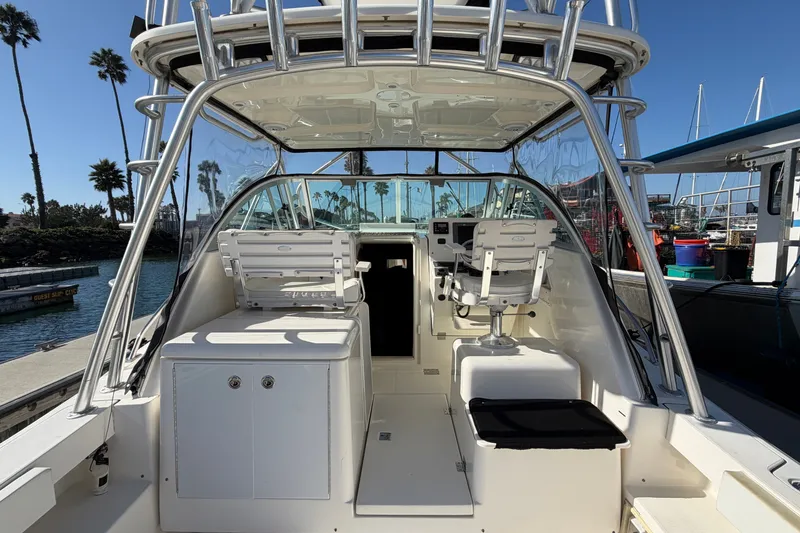 Slide: The Image of 2007 Rampage 30 Express boat interior with helm, seating, and marina backdrop. - 21