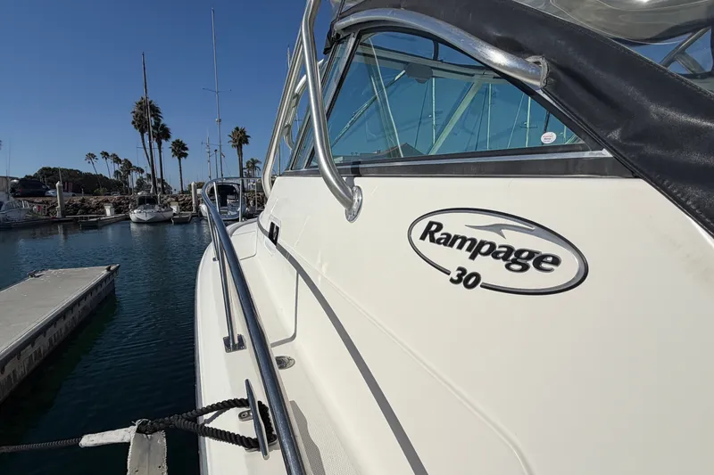 Slide: The Image of 2007 Rampage 30 Express boat docked at marina with palm trees in background. - 13