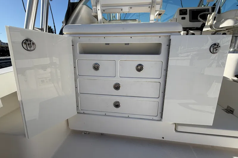 Slide: The Image of 2007 Rampage 30 Express boat interior with open storage cabinet and drawers. - 22