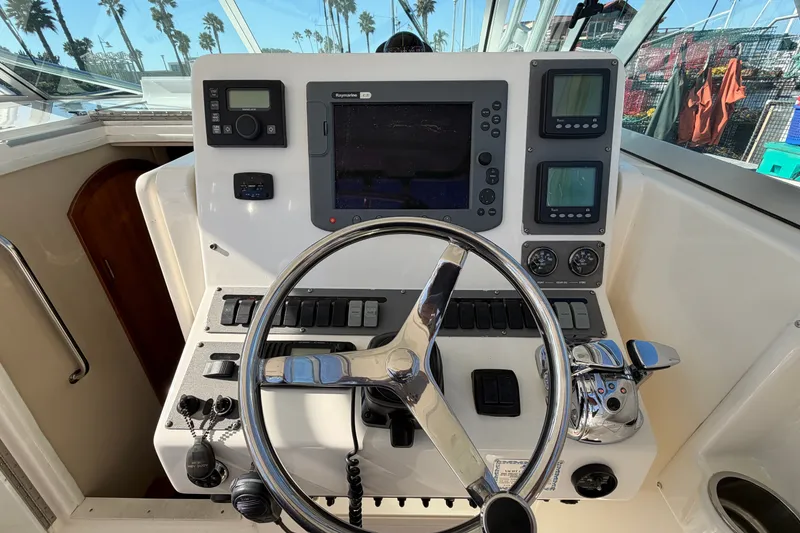 Slide: The Image of Control panel of a 2007 Rampage 30 Express boat with steering wheel and navigation equipment. - 30