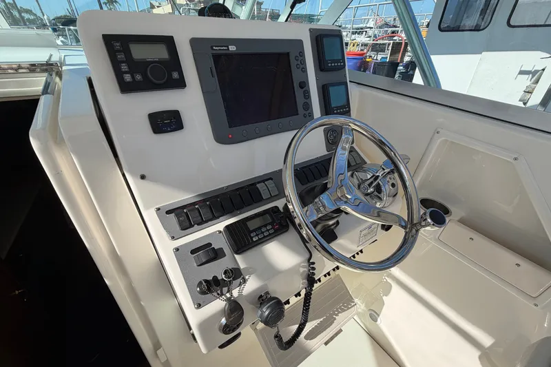 Slide: The Image of Control panel of a 2007 Rampage 30 Express boat with steering wheel and navigation equipment. - 28
