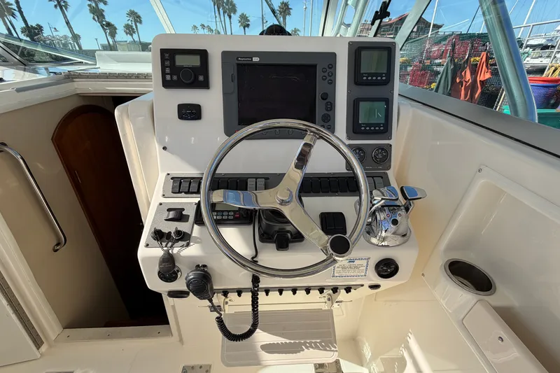 Slide: The Image of 2007 Rampage 30 Express boat helm with steering wheel and navigation controls. - 29