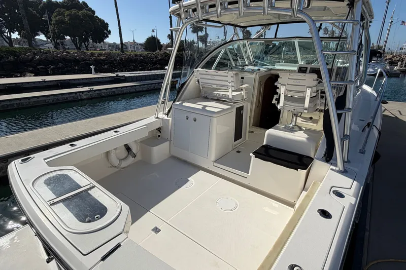 Slide: The Image of 2007 Rampage 30 Express boat interior at marina, featuring seating and helm area. - 14