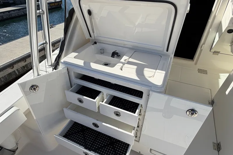Slide: The Image of 2007 Rampage 30 Express boat interior with open storage compartments and sink. - 24