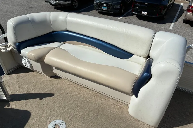 Slide: The Image of 2008 SUNTRACKER Party Barge 21 boat seating, beige and blue upholstery, parked in a lot. - 15