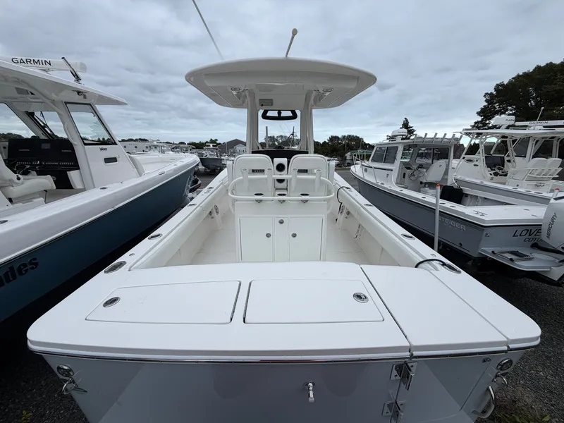 Slide: The Image of A 2021 Regulator 28 boat with a spacious deck and two seats, surrounded by other boats. - 13