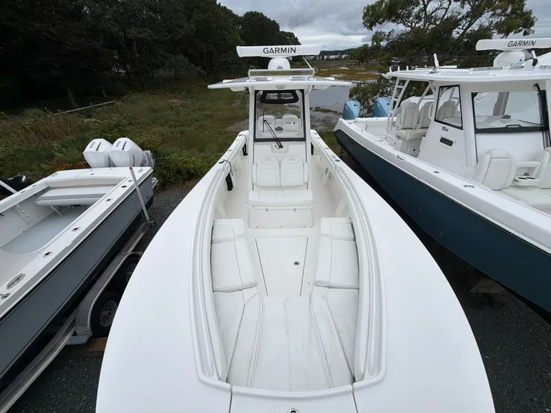 Slide: The Image of A 2021 Regulator 28 boat with a white hull and Garmin equipment, parked next to other boats. - 35