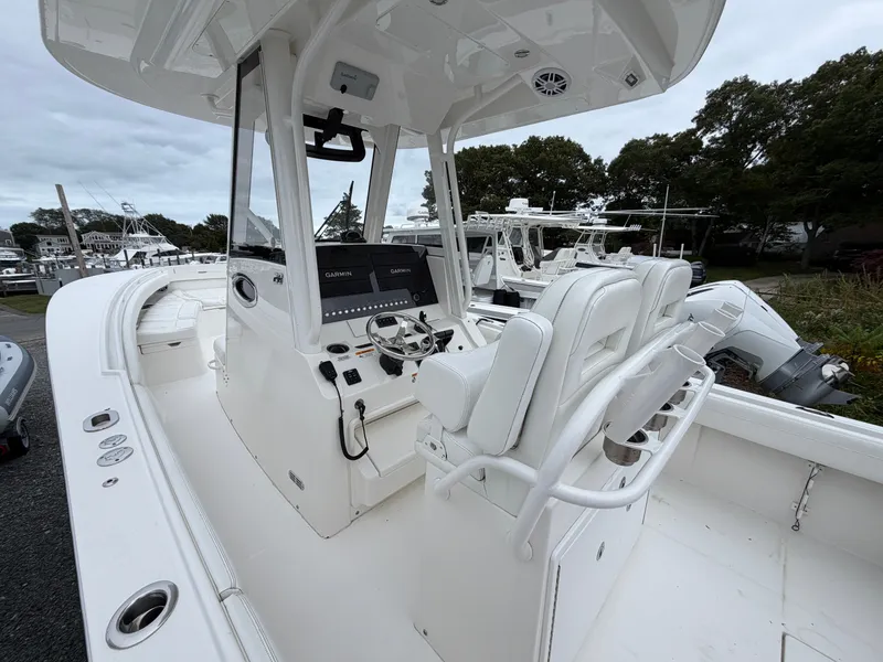 Slide: The Image of 2021 Regulator 28 with modern helm and comfortable seating, docked in a marina. - 19