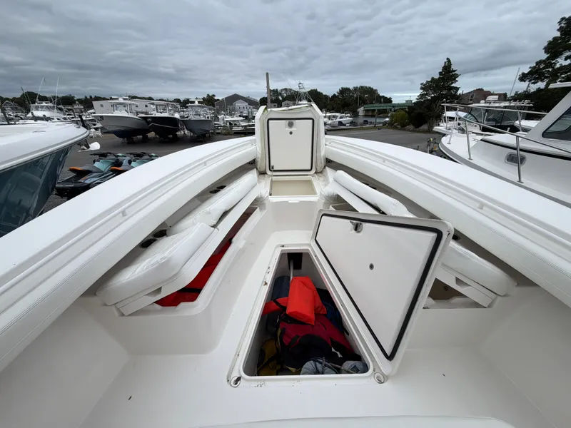 Slide: The Image of The image shows the bow of a 2021 Regulator 28 boat with storage compartments and life jackets. - 33