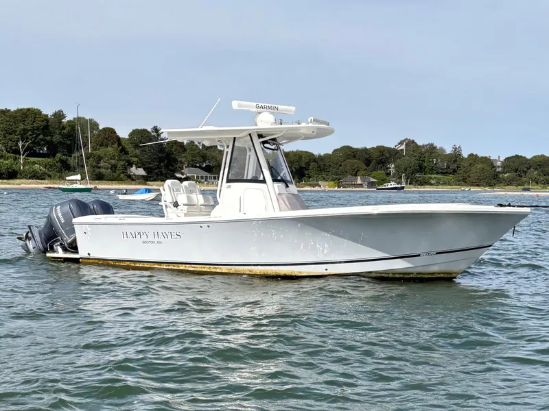 The Image of A 2021 Regulator 28 boat on the water, featuring twin outboard engines and a T-top. - 1
