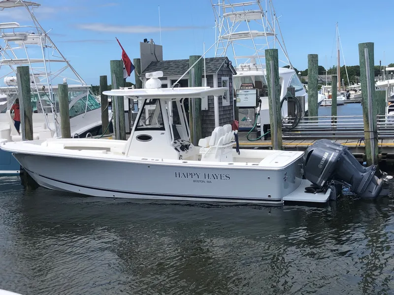 The Image of A 2021 Regulator 28 boat docked. It features a white hull and twin outboard engines. - 1