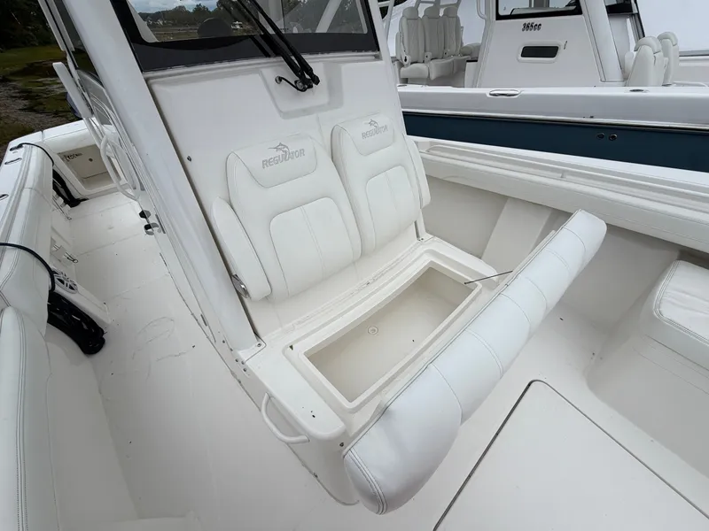Slide: The Image of The image shows the seating area of a Regulator 28 boat with white upholstery. - 39