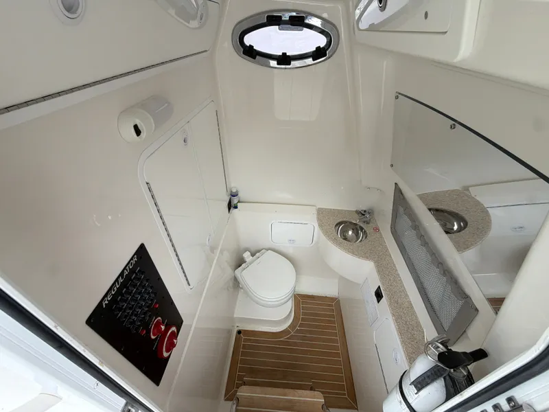 Slide: The Image of Interior of a 2021 Regulator 28 with a toilet, sink, and wood flooring. - 40