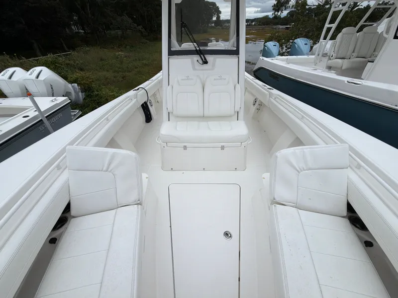 Slide: The Image of The image shows the cockpit of a 2021 Regulator 28 boat with white seating. - 32