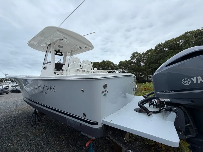 Slide: The Image of 2021 Regulator 28 with Yamaha outboard motor, parked on gravel, surrounded by trees. - 11
