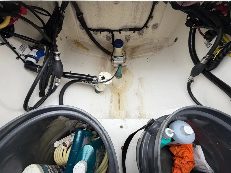 Slide: The Image of An open storage area in the boat with cleaning supplies and hoses. - 16