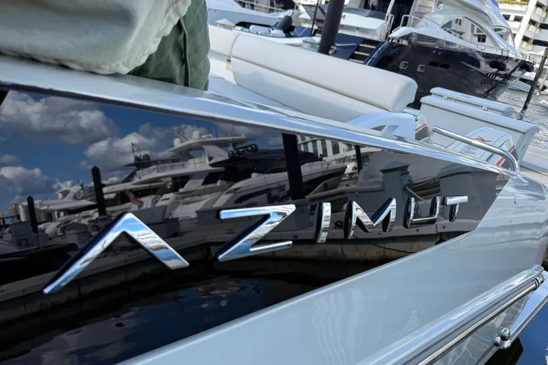 Slide: The Image of 2023 Azimut Verve 47 yacht with sleek design and reflective surface at marina. - 14
