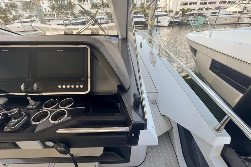 Slide: The Image of Cockpit view of 2023 Azimut Verve 47 yacht with modern controls and docked boats. - 42