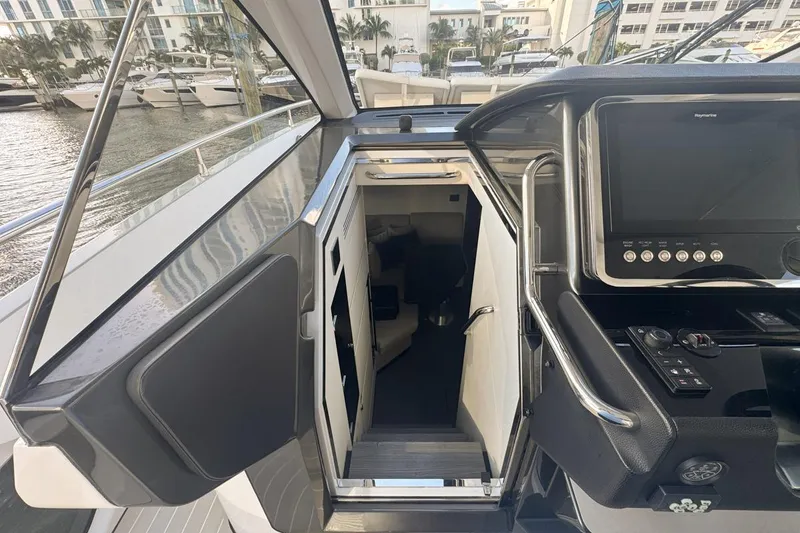 Slide: The Image of 2023 Azimut Verve 47 yacht interior entrance with control panel and marina view. - 38