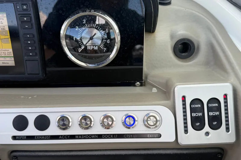 Slide: The Image of Dashboard controls of 2023 Crownline Eclipse E235 XS boat, featuring RPM gauge and switches. - 38