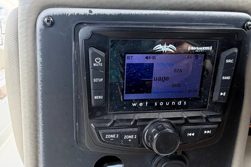 Slide: The Image of 2023 Crownline Eclipse E235 XS boat stereo system displaying music track information. - 34