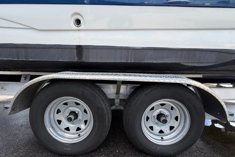Slide: The Image of Trailer wheels of 2023 Crownline Eclipse E235 XS boat on wet pavement. - 78