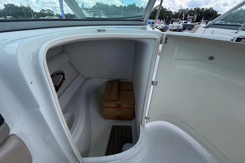 Slide: The Image of 2023 Crownline Eclipse E235 XS boat storage compartment with cardboard box inside. - 26