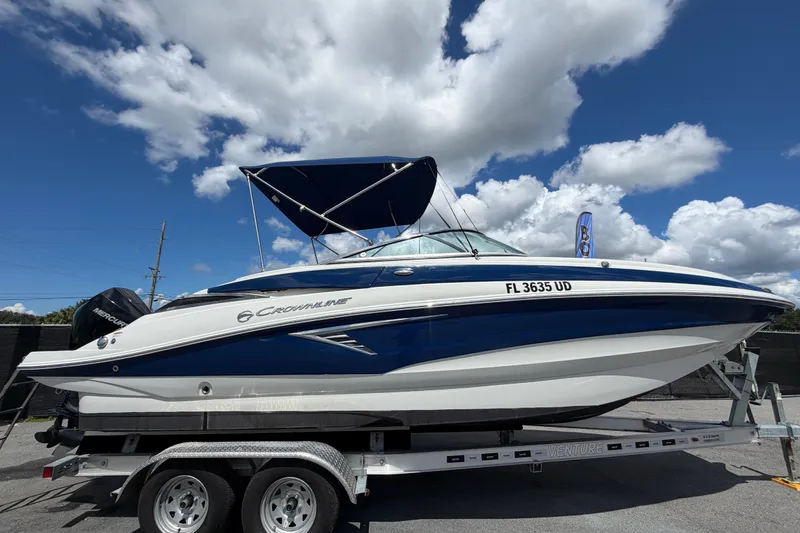 Slide: The Image of 2023 Crownline Eclipse E235 XS boat on trailer under blue sky. - 1