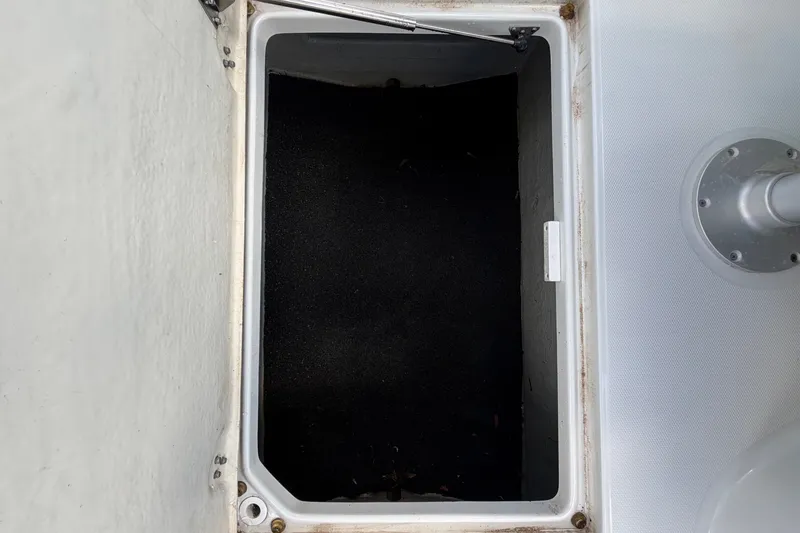 Slide: The Image of An open storage compartment on a boat with a black interior. - 22