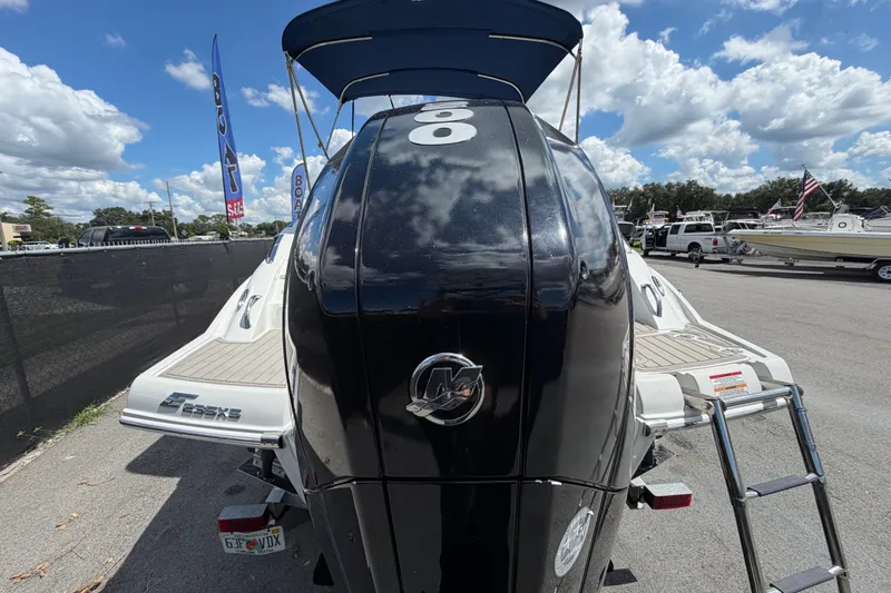 Slide: The Image of 2023 Crownline Eclipse E235 XS boat with powerful outboard motor, parked outdoors. - 3