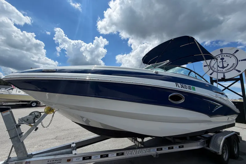 Slide: The Image of 2023 Crownline Eclipse E235 XS boat on trailer under cloudy sky. - 9