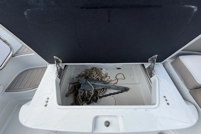 Slide: The Image of Open storage compartment on 2023 Crownline Eclipse E235 XS boat with anchor and rope. - 65