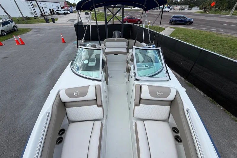 Slide: The Image of 2023 Crownline Eclipse E235 XS boat interior with seating and windshield, parked outdoors. - 55
