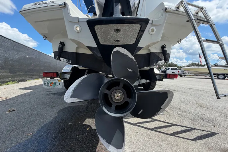 Slide: The Image of 2023 Crownline Eclipse E235 XS boat propeller and stern view in a parking lot. - 4