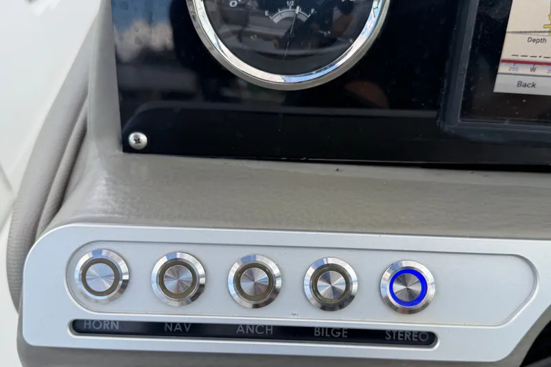 Slide: The Image of Dashboard controls of 2023 Crownline Eclipse E235 XS boat, featuring labeled buttons. - 39