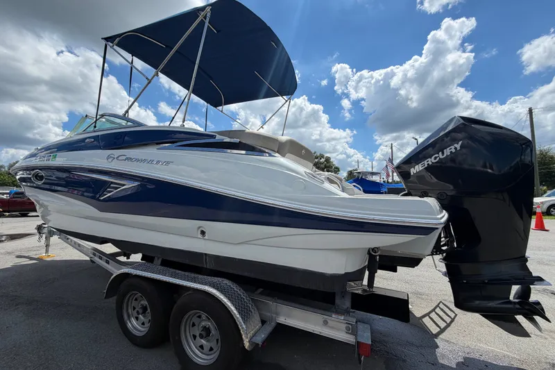 Slide: The Image of 2023 Crownline Eclipse E235 XS boat with Mercury engine on trailer under blue sky. - 7